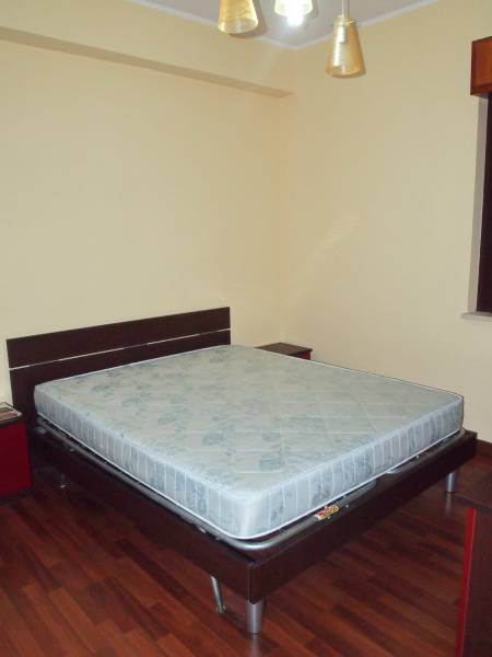 Predaj bytu 3-izbového (3+kk) s rozlohou 65 m² a terasou 10 m², Scalea - Spálňa v 3-izbovom byte s manželskou posteľou a drevenou podlahou.