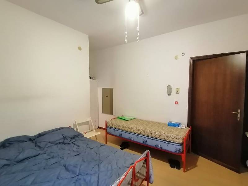 Predaj bytu 1-izbového, 25 m² s balkónom, Scalea - Dve postele a stolička v miestnosti 1-izbového bytu.