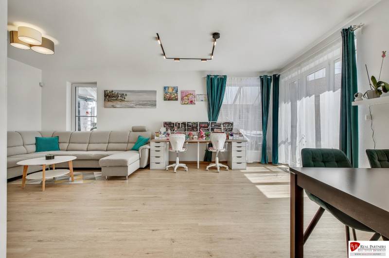 Predaj 4 izbový dom.100 m2, pozemok 208 m2, Štúrova ul, Stupava - Obývacia izba s pohovkou a pracovným stolom v rodinnom dome, svetlá miestnosť s oknami.