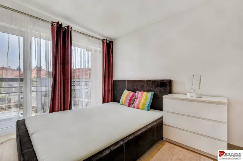 Predaj 4 izbový dom.100 m2, pozemok 208 m2, Štúrova ul, Stupava - Spálňa v rodinnom dome s posteľou a komodou, doplnená o farebné vankúše.