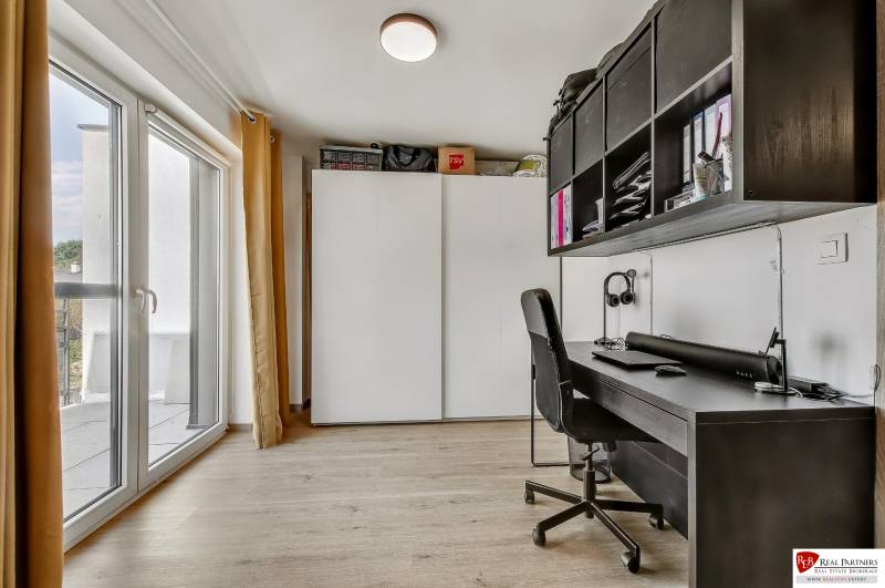 Predaj 4 izbový dom.100 m2, pozemok 208 m2, Štúrova ul, Stupava - Pracovný kút v rodinnom dome s veľkým oknom, stôl, stolička a úložné priestory.