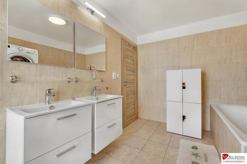 Predaj 4 izbový dom.100 m2, pozemok 208 m2, Štúrova ul, Stupava - Kúpeľňa v rodinnom dome s dvojitým umývadlom, bielou skriňou a vaňou.