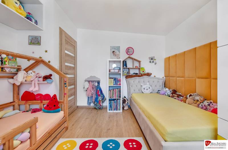 Predaj 4 izbový dom.100 m2, pozemok 208 m2, Štúrova ul, Stupava - Detská izba v rodinnom dome s posteľami, poličkami a hračkami, svetlé drevené podlahy.
