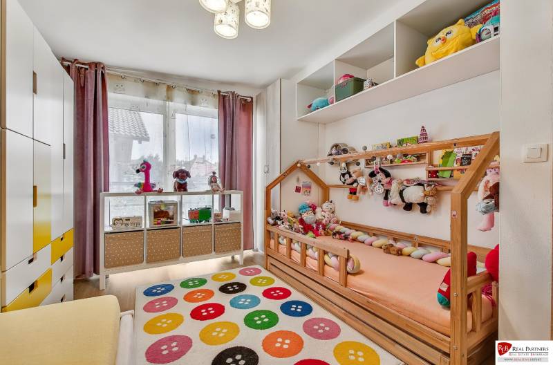 Predaj 4 izbový dom.100 m2, pozemok 208 m2, Štúrova ul, Stupava - Detská izba v rodinnom dome s hračkami a farebným kobercom.