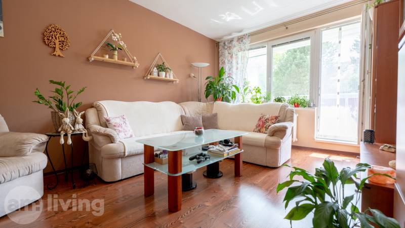 SVETLÝ – 3i s balkónom 69 m² – TOP lokalita Nová Dubnica - Svetlý obývací priestor v 3-izbovom byte s kvetinovou výzdobou a pohodlnou sedačkou.