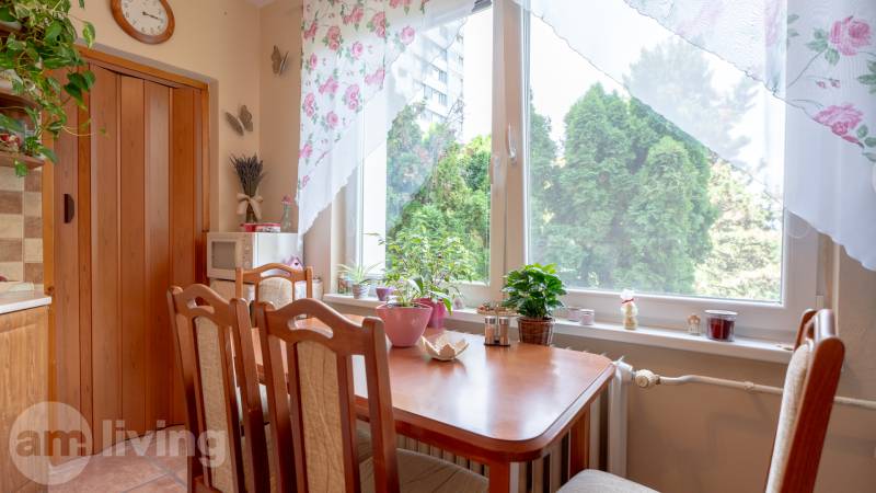 SVETLÝ – 3i s balkónom 69 m² – TOP lokalita Nová Dubnica - Jedáleň v 3-izbovom byte s dreveným stolom, stoličkami a izbovými rastlinami.