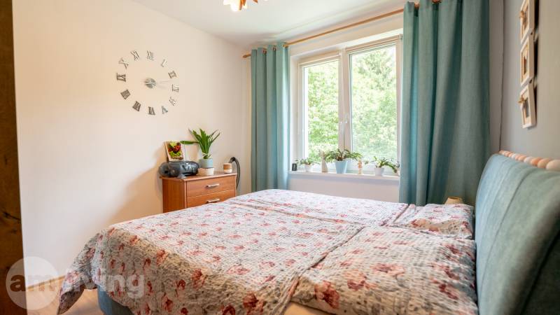SVETLÝ – 3i s balkónom 69 m² – TOP lokalita Nová Dubnica - Spálňa v 3-izbovom byte s posteľou, nočným stolíkom a dekoračnými rastlinami.