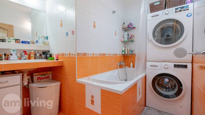 SVETLÝ – 3i s balkónom 69 m² – TOP lokalita Nová Dubnica - Kúpeľňa v 3-izbovom byte s práčkou a sušičkou, oranžové obklady, vaňa.