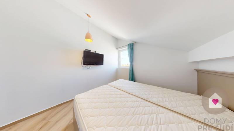 PAG/MANDRE - 2 apartmány za cenu jedného - 190m od mora - Spálňa so šikmým stropom, posteľou, televízorom a závesmi v 4-izbovom byte.