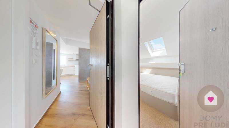 PAG/MANDRE - 2 apartmány za cenu jedného - 190m od mora - Interiér 4-izbového bytu s drevenou podlahou, zrkadlom a svetlou kuchyňou.