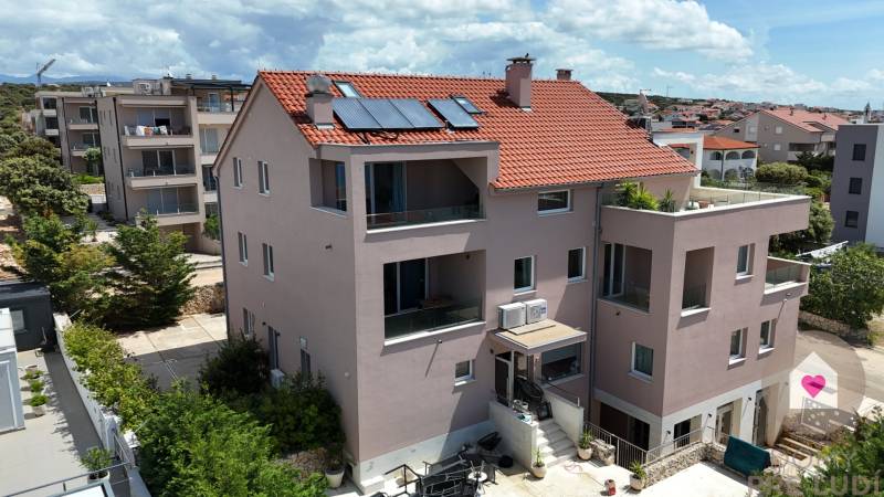 PAG/MANDRE - 2 apartmány za cenu jedného - 190m od mora - Exteriér 4-izbového bytu v meste Pag ukazuje viacposchodovú budovu s terasou.