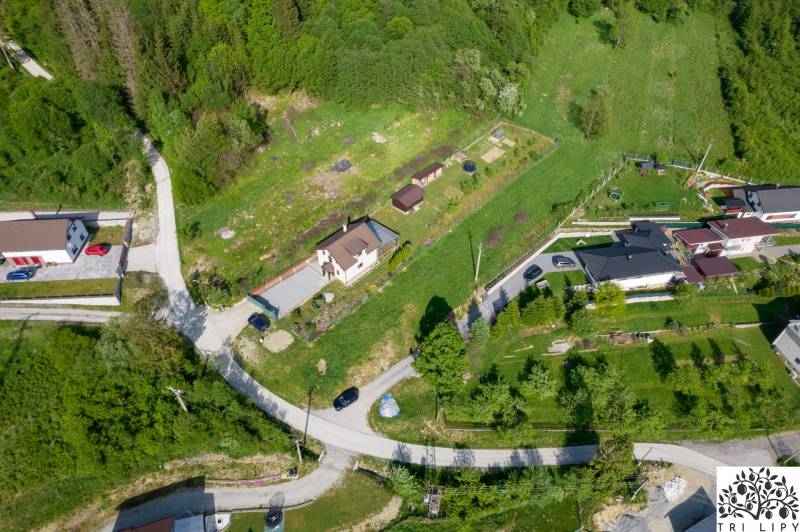 Stavebný pozemok na predaj - Raková - Letecký pohľad na Pozemky - bývanie v meste Raková obklopené zeleňou a cestami.