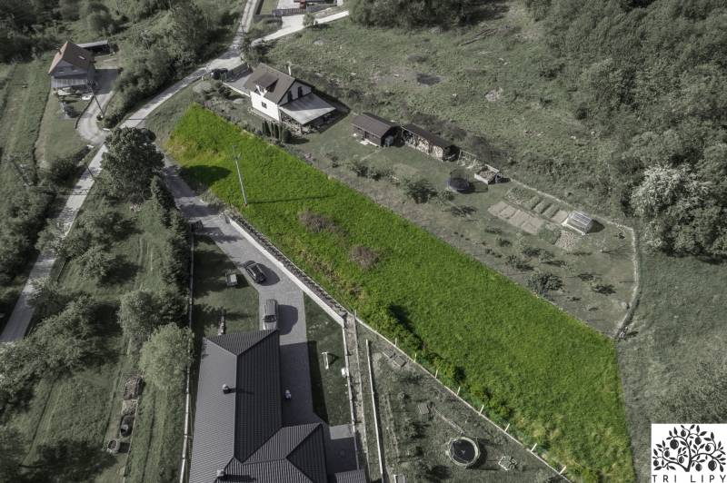 Stavebný pozemok na predaj - Raková - Letecký pohľad na pozemky vhodné na bývanie v Rakovej, obklopené zeleňou a domami.