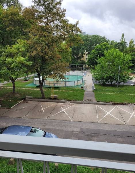 3-izb. byt, Mesačná ul., Ružinov, lodžia, 2.p./8 - Výhľad z 3-izbového bytu v Bratislave - Ružinove na Mesačnej ulici, parkovisko, stromy a ihrisko.