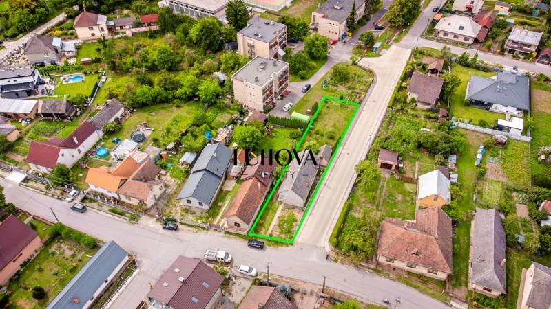 LADCE_Dom na rekonštrukciu podľa vašich predstáv  - Letecká fotografia ulice Pavla Koyša v Ladcoch, znázorňujúca rodinné domy a okolité záhrady.