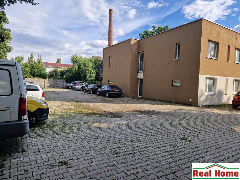 PEZINOK - PRENÁJOM: Byt s výmerou 31 m2, terasou a vlastným parkovaním - Parkovisko na Tehelnej ulici v Pezinku s autami a budovou, miesto pre 1-izbový byt.