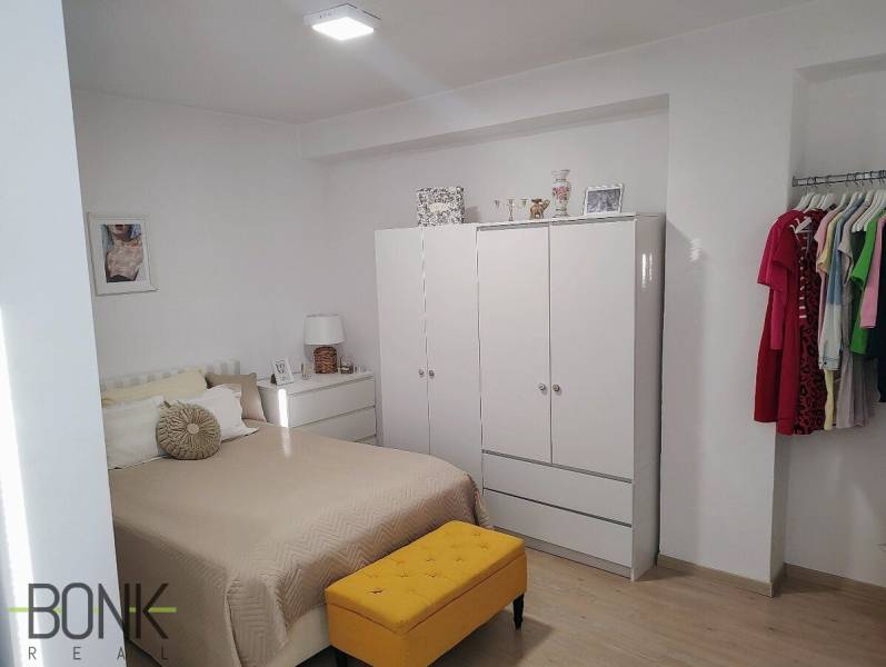 Predaj 2 izbový byt, vedený ako apartmán, možnosť hypo, Hviezdna ulica - Svetlá spálňa v 2-izbovom byte so šatníkom, posteľou a farebným nábytkom.