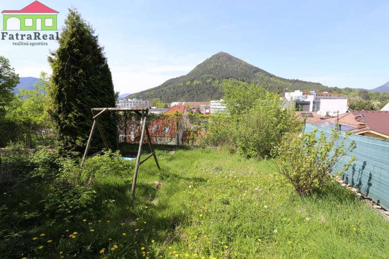 Rodinný dom v rekonštrukcii, Ružomberok - Na ulici Nám. A. Hlinku, zelený pozemok rodinného domu s hojdačkou, výhľad na kopce.