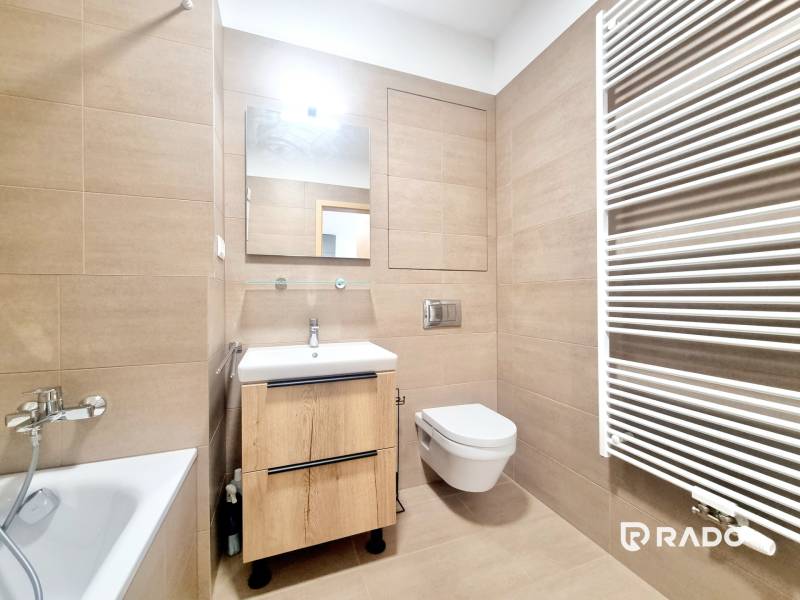 | EXKLUZÍVNE! | Krásny NOVÝ 2-izbový byt | 48m² | Čerešne - Kúpeľňa v 2-izbovom byte s vaňou, umývadlom, toaletou a rebríkovým radiátorom.