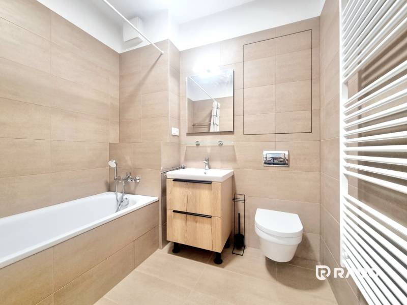 | EXKLUZÍVNE! | Krásny NOVÝ 2-izbový byt | 48m² | Čerešne - Kúpeľňa v 2-izbovom byte s vaňou, umývadlom, toaletou a rebríkovým radiátorom.