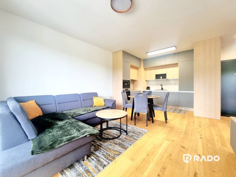 | EXKLUZÍVNE! | Krásny NOVÝ 2-izbový byt | 48m² | Čerešne - Obývacia izba v 2-izbovom byte s kuchynským kútom a jedálenským stolom.