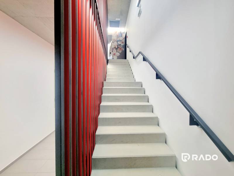 | EXKLUZÍVNE! | Krásny NOVÝ 2-izbový byt | 48m² | Čerešne - Schodisko s červenou stenou a bielymi schodmi v 2-izbovom byte.