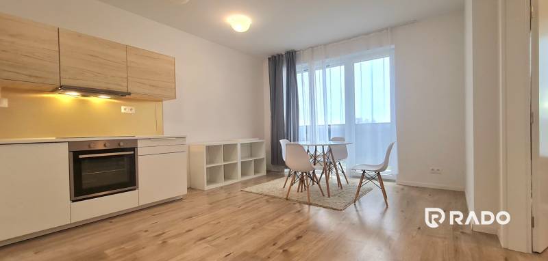 | Priestranný 3-izbový byt  | 80 ㎡ | Slnečnice-Petržalka - Jasná kuchyňa s bielymi skrinkami a jedálenským stolom v 3-izbovom byte.