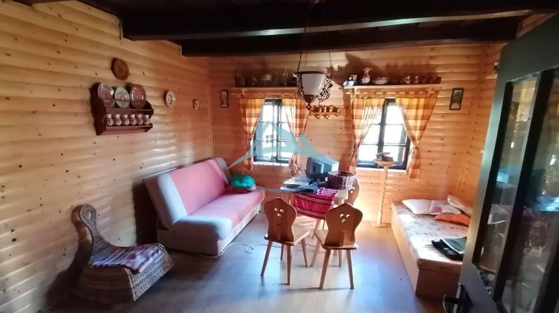 Dva malebné vidiecke domy na rozľahlom pozemku (1,6ha) v osade Prieloh - Interiér rodinného domu s dreveným obkladom, pohovkou a tradičným nábytkom.