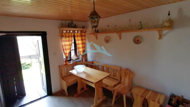 Dva malebné vidiecke domy na rozľahlom pozemku (1,6ha) v osade Prieloh - Vidiek interiér ponúka drevenú lavicu a stôl, nábytok doladzuje atmosféru rodinného domu.