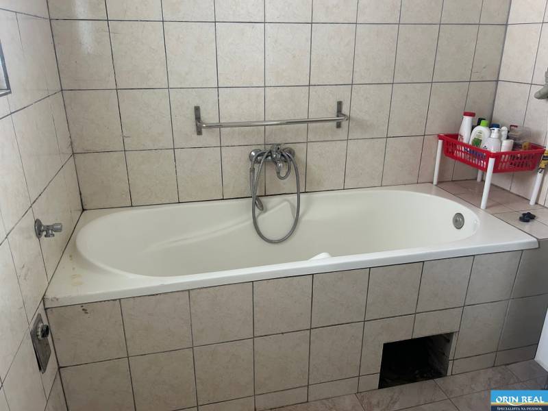 PREDAJ DOMU V ŠTEFANOVEJ S VEĽKÝM POZEMKOM - 2 399 m2 - Kúpeľňa s vaňou obloženou dlaždicami v rodinnom dome s poličkou na kozmetiku.