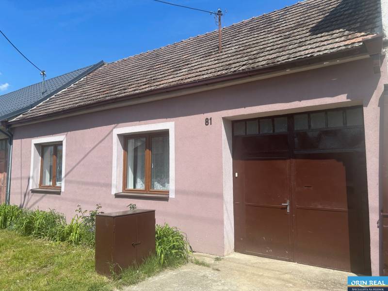 PREDAJ DOMU V ŠTEFANOVEJ S VEĽKÝM POZEMKOM - 2 399 m2 - Rodinný dom na Hlavnej ulici v Štefanovej má ružovú fasádu a trávnik.
