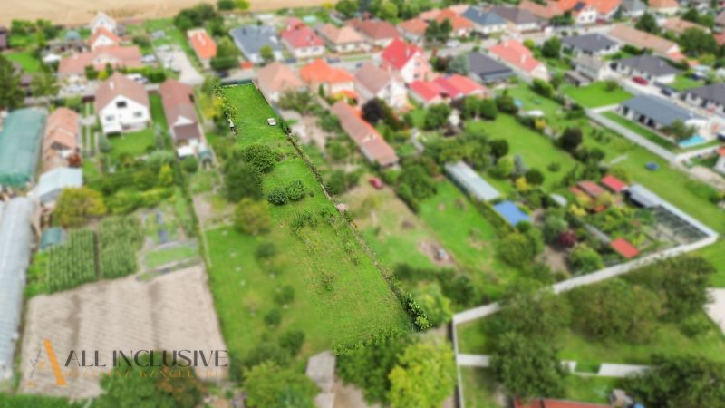 NA PREDAJ STAVEBNÝ POZEMOK - 1266 m², ROHOVCE - Letecký pohľad na pozemky pre bývanie v Rohovciach, so zeleňou a susednými domami.