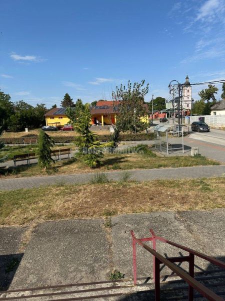 Dobré reality - Polyfunkčný objekt na predaj - Park a okolité budovy v Tekovských Lužanoch s kostolom v pozadí.