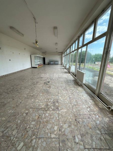 Dobré reality - Polyfunkčný objekt na predaj - Interiér budovy so sklenenými stenami a kamennou podlahou, prázdna miestnosť.