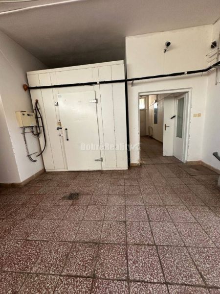 Dobré reality - Polyfunkčný objekt na predaj - Interiér budovy s dlažbou, bielymi dverami a inštaláciami na stene.