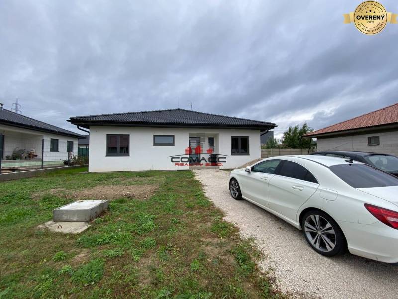 Výstavba inteligentného 4 izbového bungalovu v NM a okolí - Rodinný dom v Novom Meste nad Váhom, so zaparkovaným autom na príjazdovej ceste.