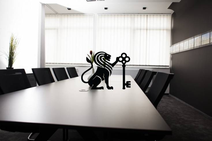Prenájom obchodného priestoru v administratívnom komplexe AB Hliny - Konferenčná miestnosť s tmavým stolom a symbolom leva, na ulici Hliny.