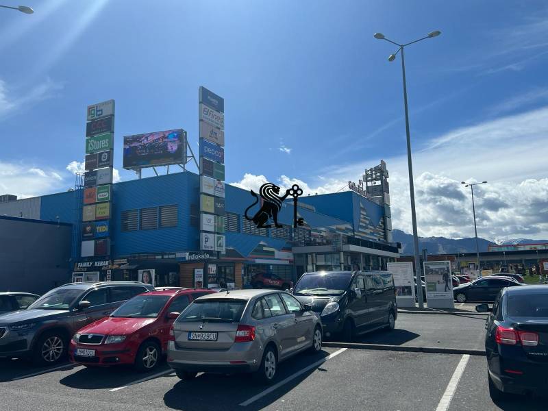 Prenájom obchodných priestorov v nákupnom centre RGB Liptov - Na ulici Kamenné pole, parkovisko pred obchodnými priestormi s výhľadom na hory.