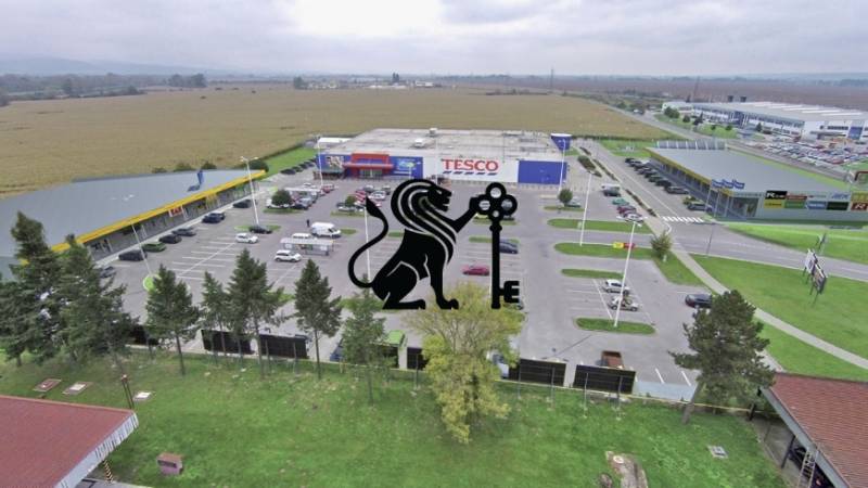 Obchodné priestory na prenájom v nákupnom centre RGB Javorina - Obrázok zobrazuje obchodné priestory na ulici Trenčianska s parkoviskom a okolitou krajinou.