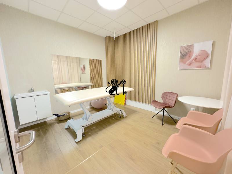 Postúpenie zabehnutej zdravotníckej prevádzky - Tomašíkova ul., BA II - Interiér miestnosti s masážnym stolom, krémovými stenami a drevenou podlahou v obchodných priestoroch.