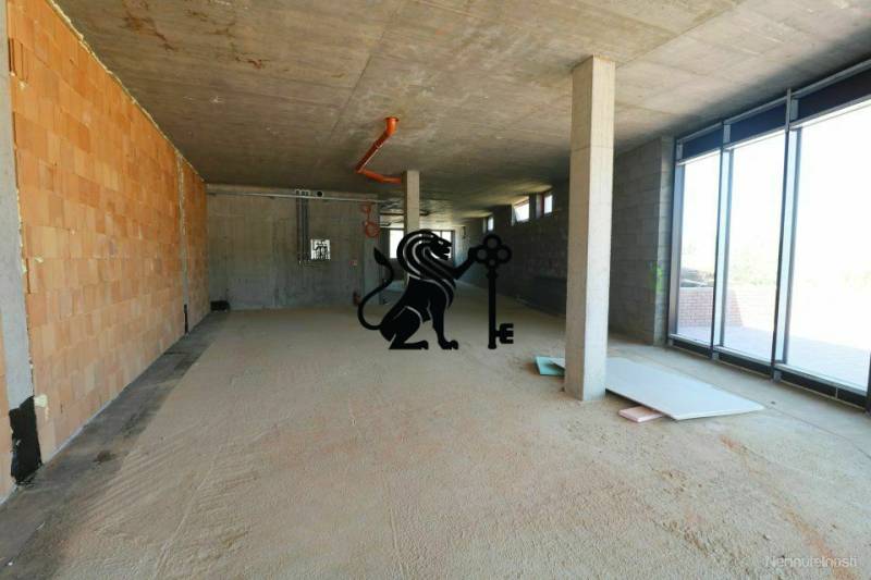 Predaj OP o výmere 86,62 m2 na predaj, Senec - Na ulici Vtáčia, nedokončené obchodné priestory s veľkými oknami a betónovými stenami.