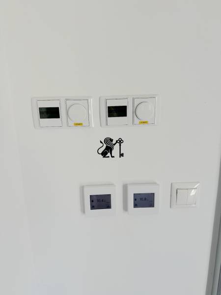 Dva domy A1 a A2 v Rači na ulici Pri vinodradoch - Na stene sú termostaty a vypínače, umiestnené na ulici Pri vinohradoch.