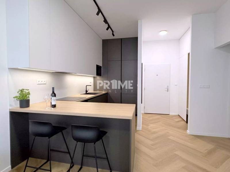 LUXUSNÝ 2i byt, KESSELBAUER, KLÍMA, LOGGIA, PARKING, Námestie 1.mája - Interiér 2-izbového bytu s modernou kuchyňou, drevenou podlahou na ulici Námestie 1.mája.