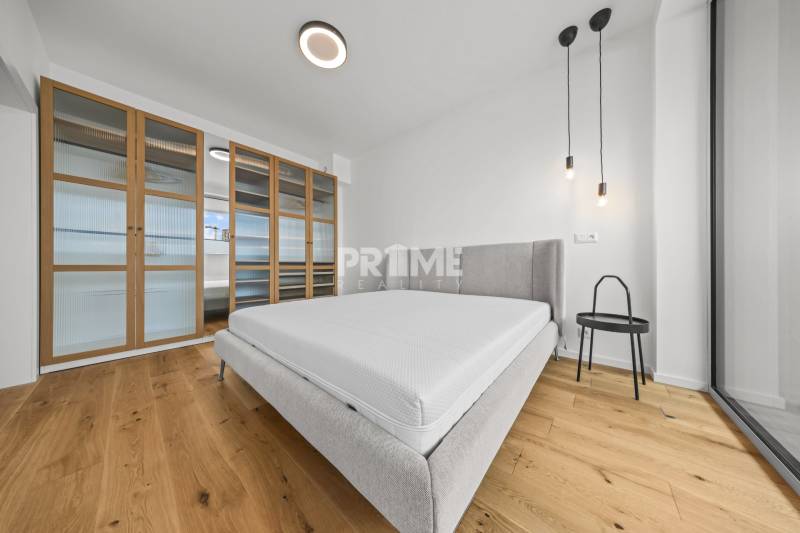 EXKLUZÍVNY MEZONETOVÝ 4i byt ( 103 m2 ), NADSTAVBA, KLÍMA, LOGGIA,NIVY - Svetlá spálňa s posteľou, skriňou a závesným osvetlením. Nachádza sa v 4-izbovom byte.