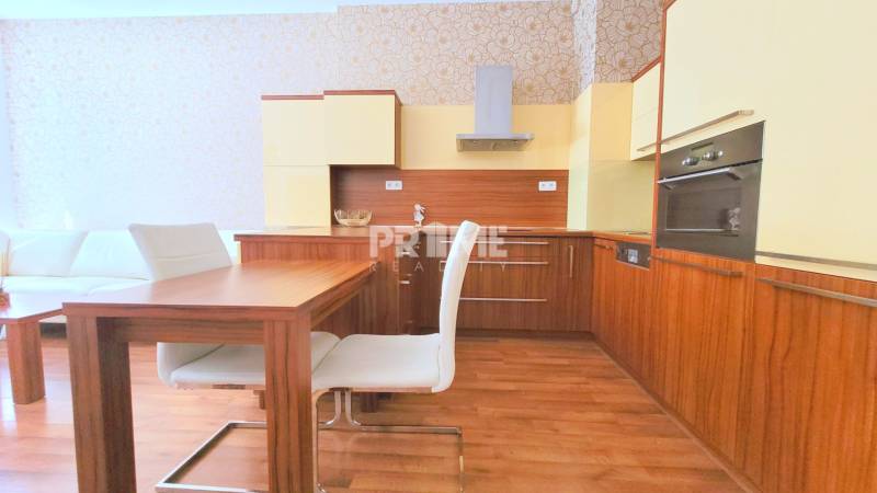 Pekný 2i byt, NOVOSTAVBA, LOGGIA, Viktoria, Košická ulica,Mlynské Nivy - Kuchyňa v 2-izbovom byte so zabudovanými spotrebičmi a dreveným jedálenským stolom.