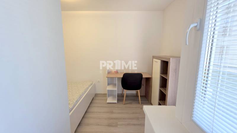 PEKNÝ 1,5i byt, CENTRUM, BALKÓN, PARKING, Kozia ulica, Staré Mesto - Jednoduchá spálňa v 1-izbovom byte s posteľou, stolom a podlahou s dreveným dekorom.
