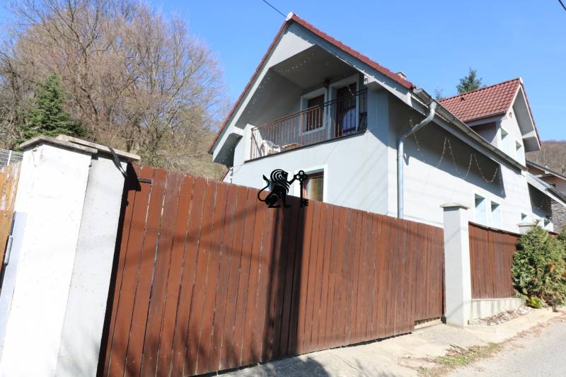 ZNÍŽENÁ cena-viacgeneračný  rodinný dom v Borinke - Rodinný dom na ulici Borinka s hnedým dreveným plotom v prostredí lesa.