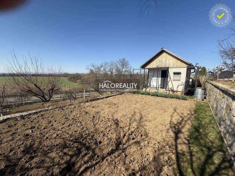 Predaj, záhradná chata Brodzany, pozemok 700 m2 - EX... - Záhrada s chatkou, pripravená na pestovanie, obklopená stromami a poľom v pozadí.