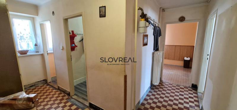 SLOVREAL - na predaj 2 izbový byt Hodruša - Hámre, 58 m2 - Chodba v 2-izbovom byte s podlahou s kockovým vzorom a radiátorom.