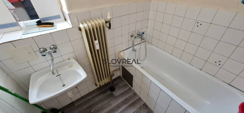 SLOVREAL - na predaj 2 izbový byt Hodruša - Hámre, 58 m2 - Kúpeľňa v 2-izbovom byte, biela keramická dlažba a radiátor pri vani.